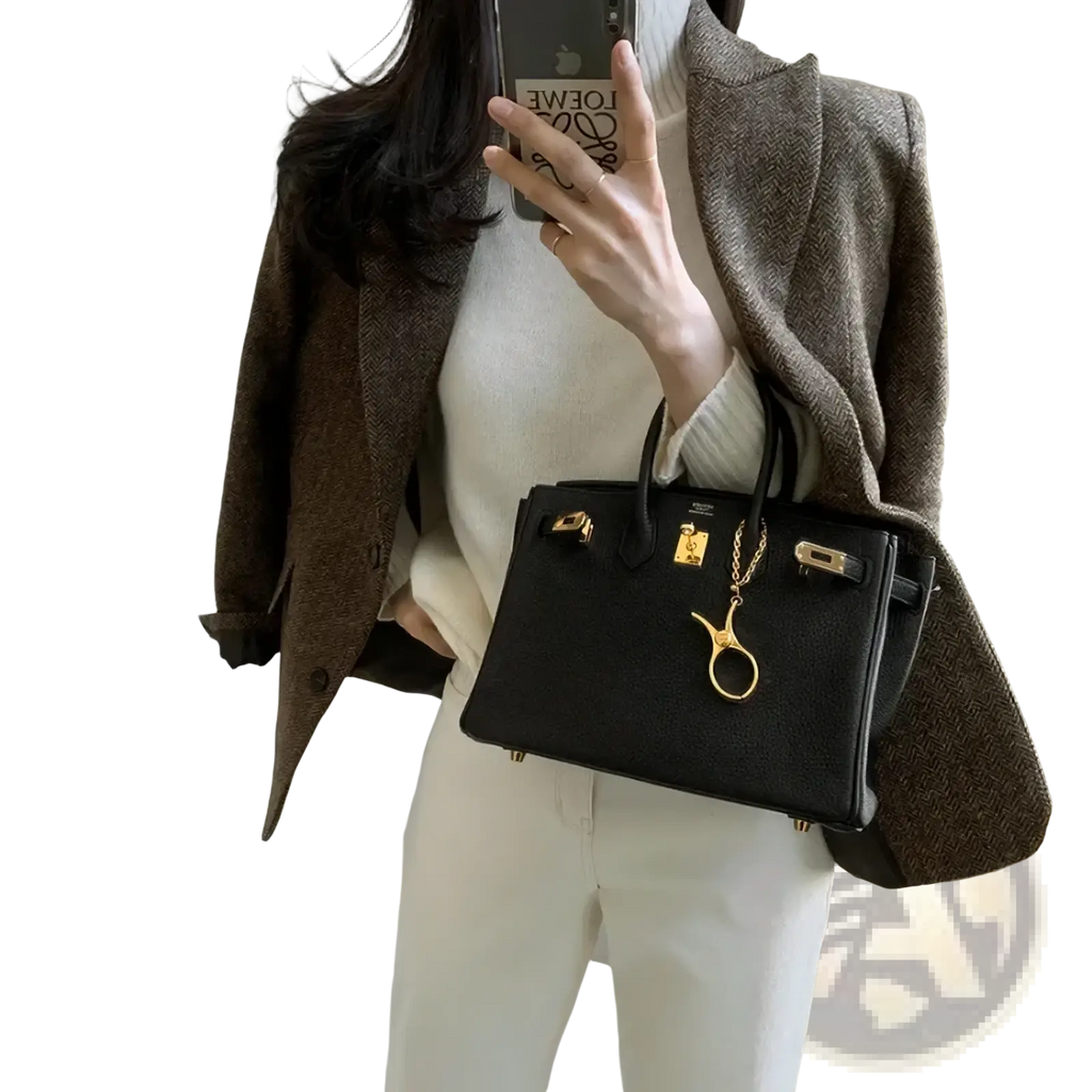 Black textured leather handbag with gold-tone hardware and golden scissors charm paired with gray wool blazer