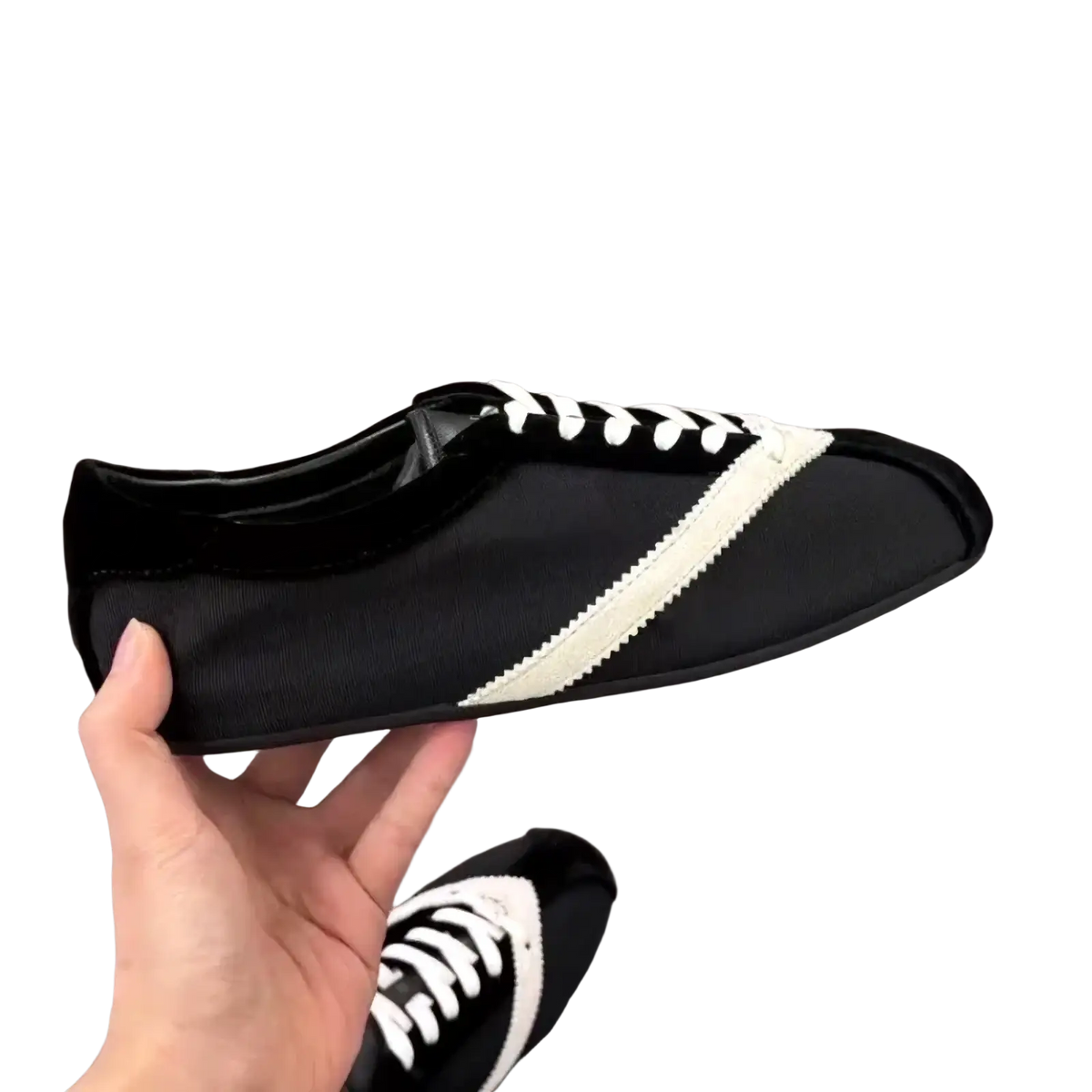 Women leather casual sneakers in black and white with a sleek minimalist design and diagonal stripe on the side
