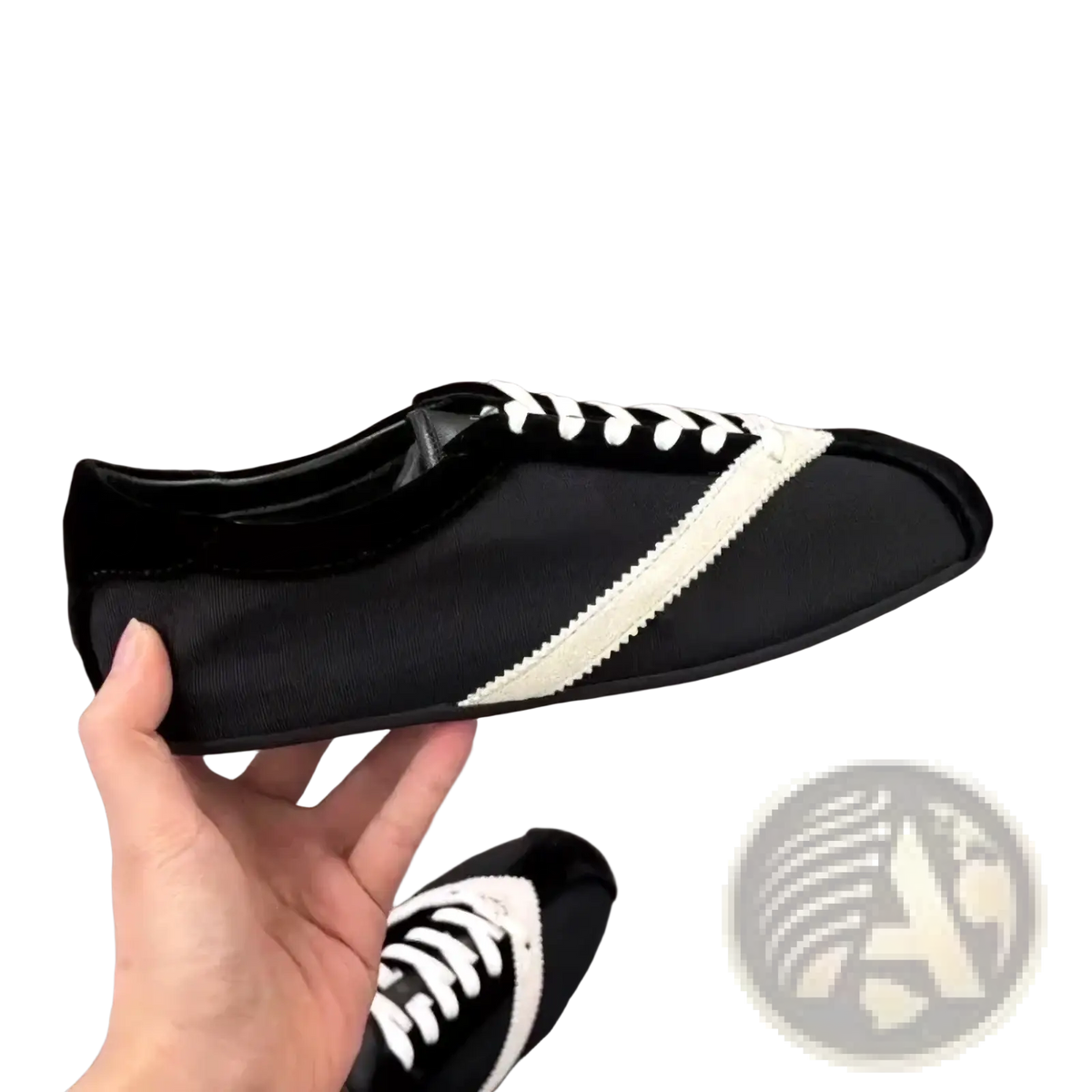 Women leather casual sneakers in black and white with a sleek minimalist design and diagonal stripe on the side