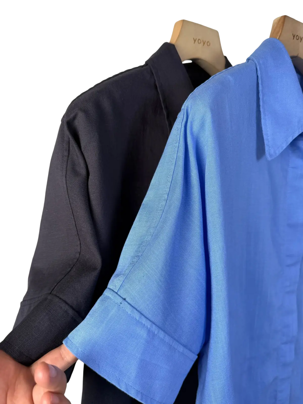A crisp blue women linen short sleeve button up shirt with subtle textured weave and folded cuffs on wooden hanger