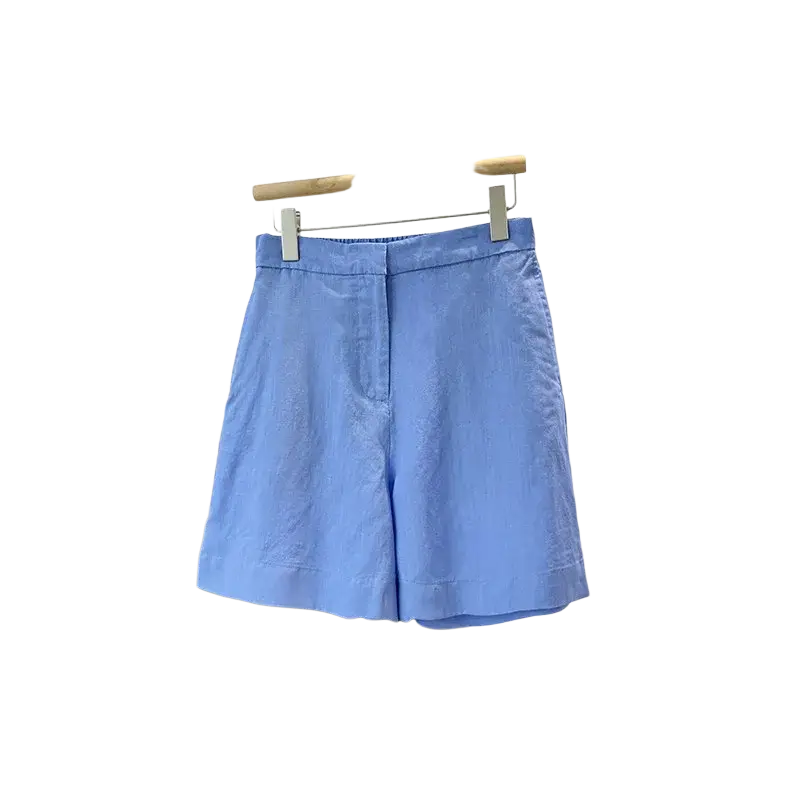 Light blue high waisted linen shorts with a clean minimalist design paired with women linen short sleeve button up shirt blue
