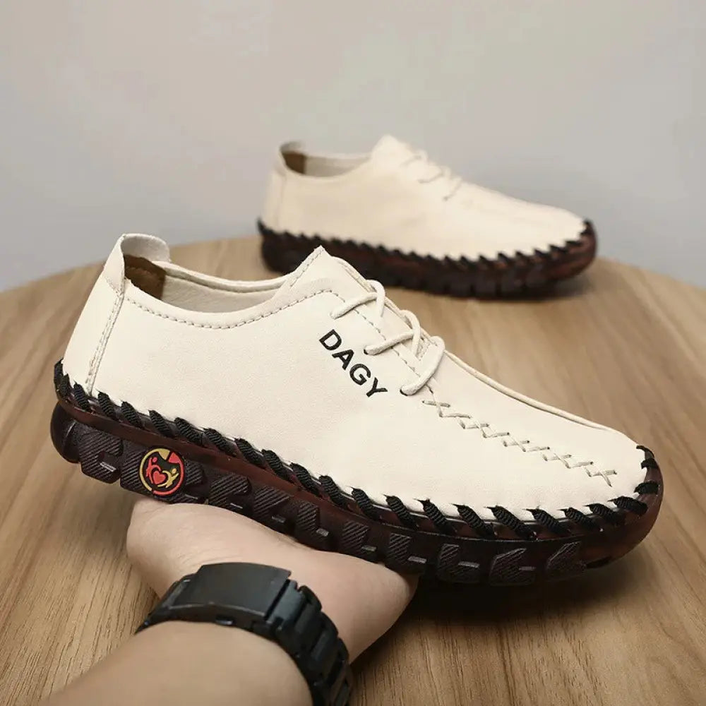 Women’s soft leather lace-up loafers in cream with black stitching and dark brown textured rubber soles