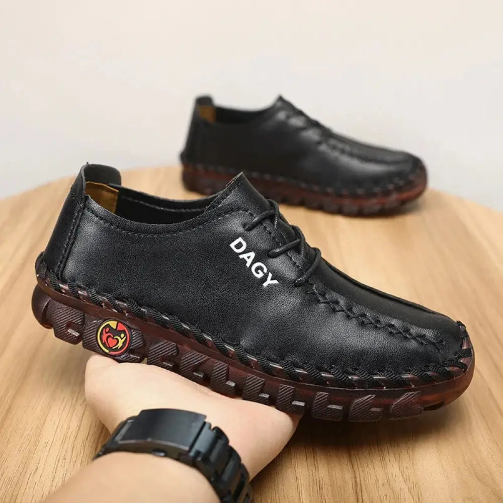 Black leather women’s soft lace-up loafers with visible stitching and brown rubber sole with dagy logo on the side