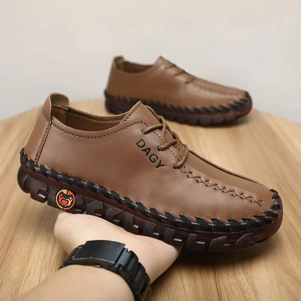 Women’s brown soft leather lace-up loafers with black braided stitching and logo on the heel, back view