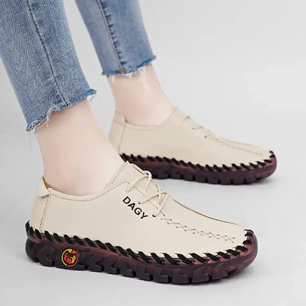 Beige leather women’s soft lace-up loafers with black stitching and dark brown rubber soles by dagy