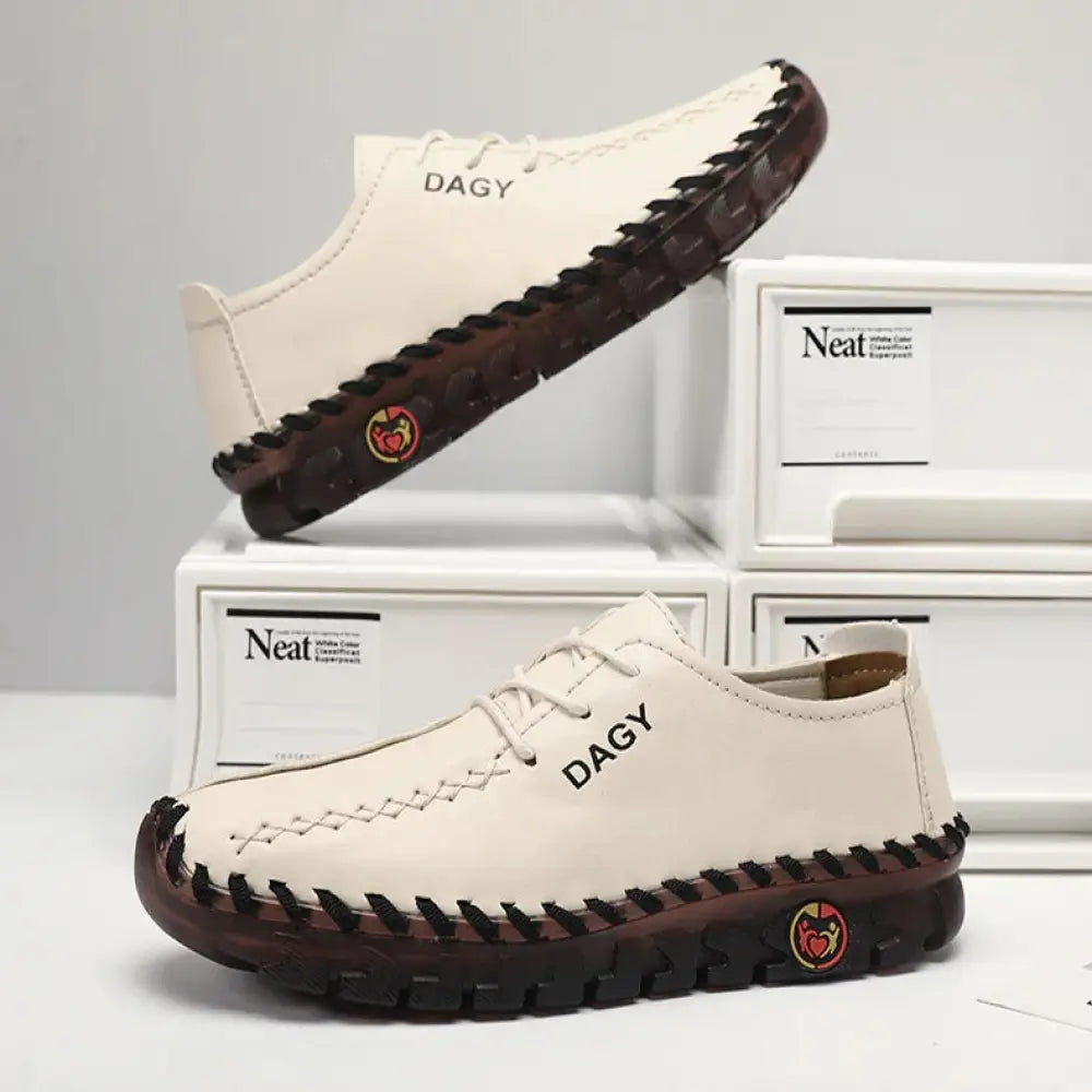 Back view of women’s cream-colored soft leather lace-up loafers with dark brown rubber stitched soles and heel logo