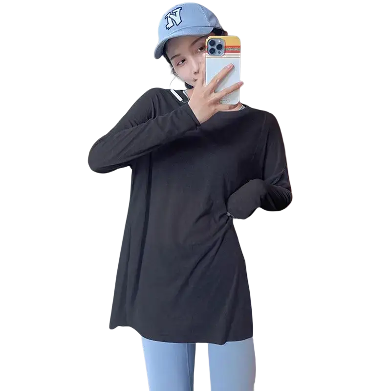 Black long sleeve athletic top with twisted front detail and white trim at neckline featuring side slit