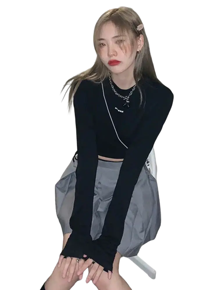 Women long sleeve crisscross black crop top with fingerless gloves and chain necklace in a stylish outfit