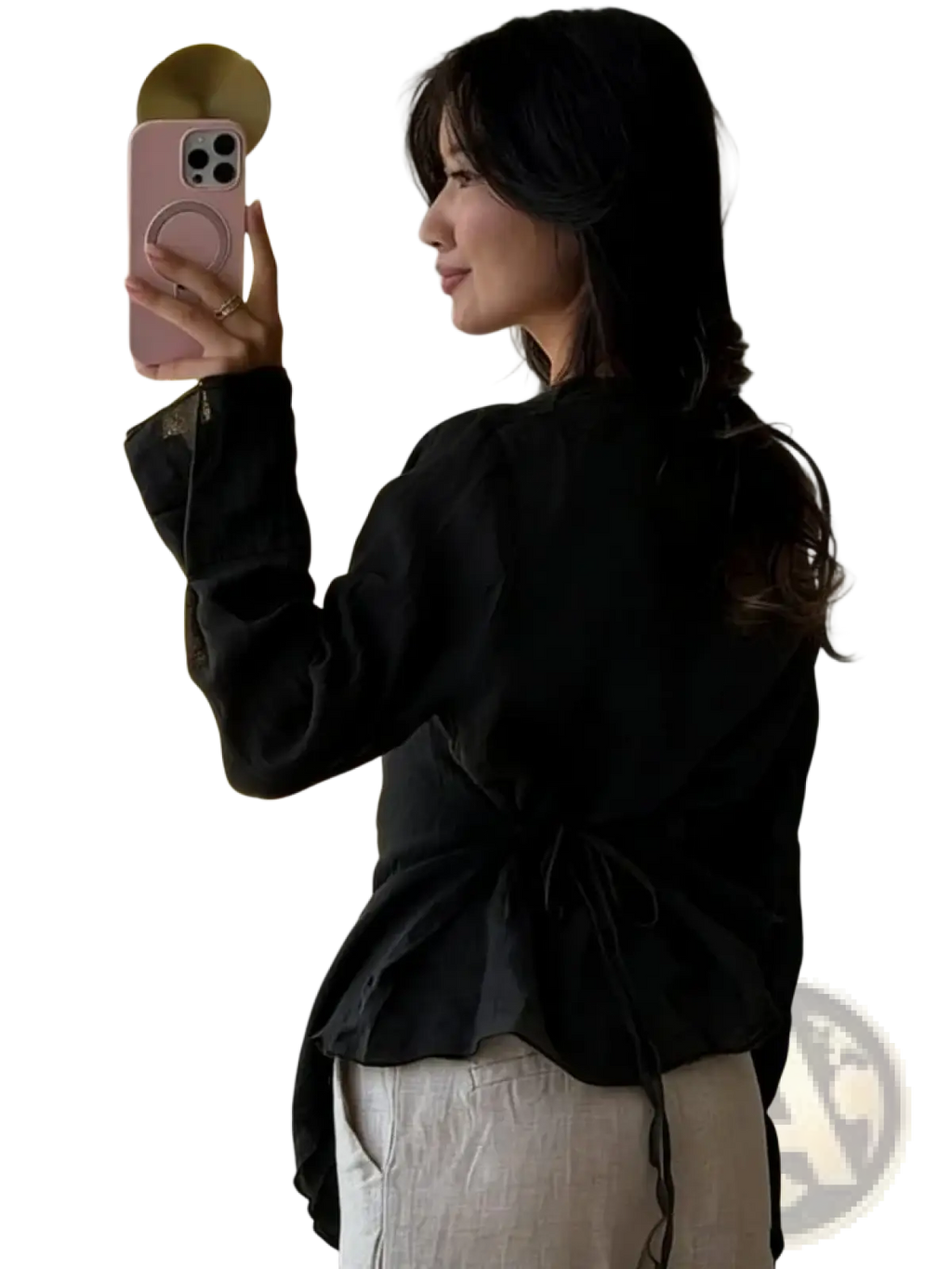 Pink phone with circular ring holder placed on a women long sleeve elegant office blouse in soft fabric