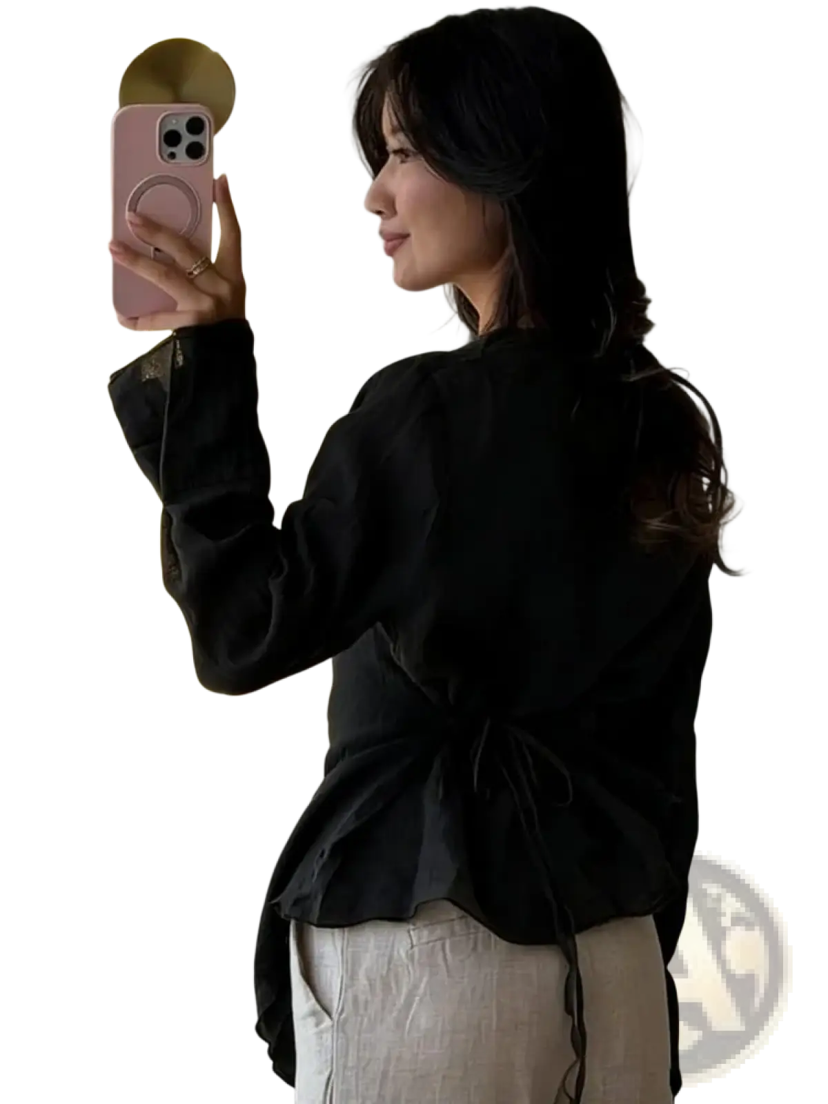 Pink phone with circular ring holder placed on a women long sleeve elegant office blouse in soft fabric
