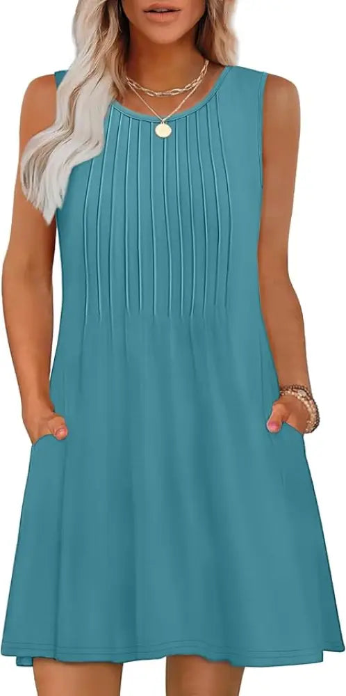 Women’s loose teal sleeveless summer beach dress with vertical pleats and side pockets featuring geometric and tropical design