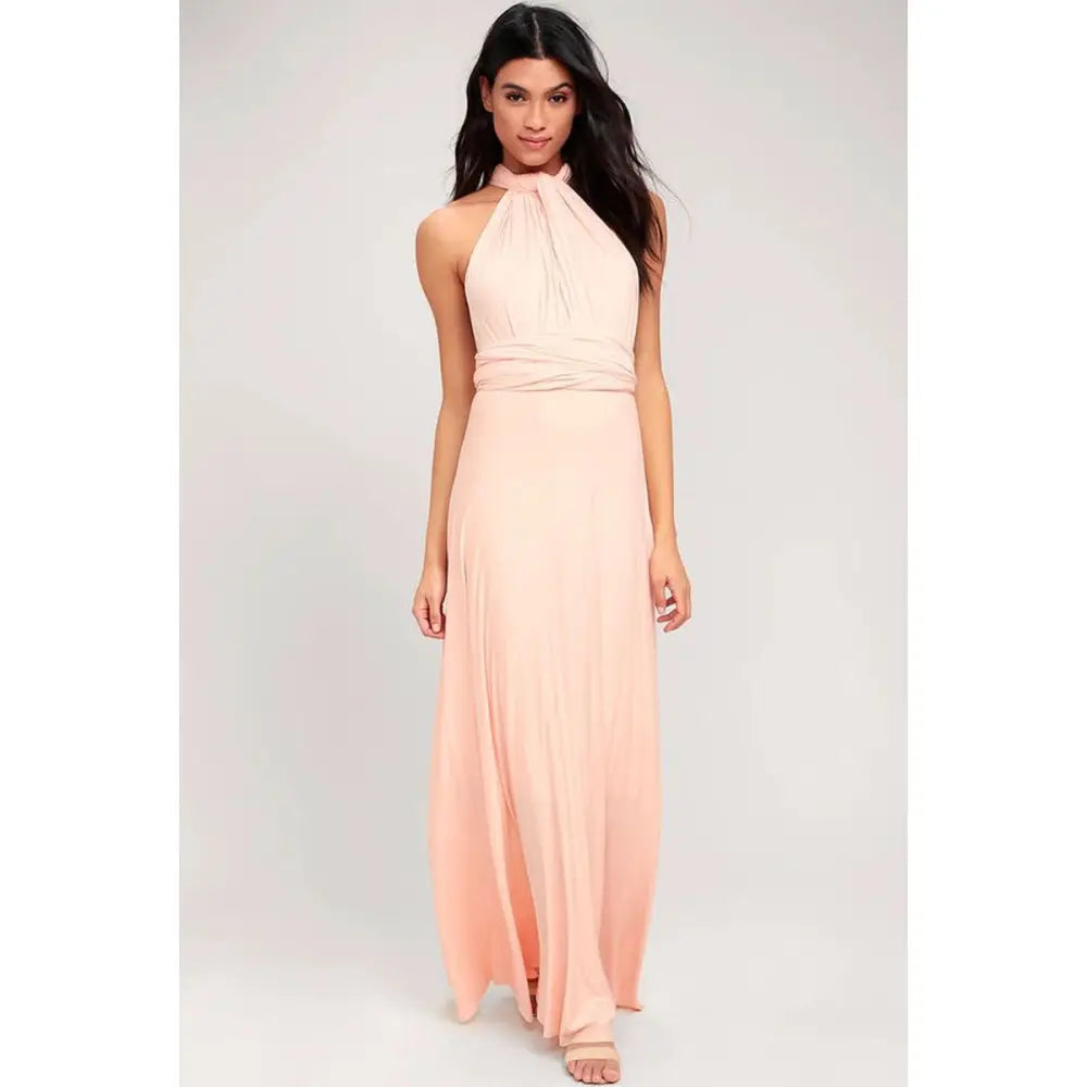 A flowing blush pink satin multiway halter neck maxi party dress with a draped waistband and high slit