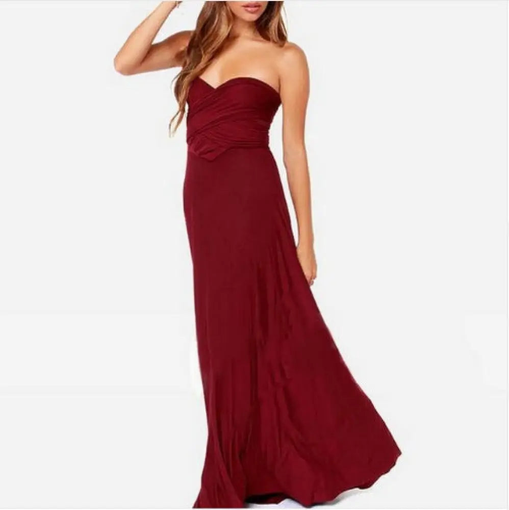 A flowing strapless burgundy satin multiway halter neck maxi party dress with a ruched bodice and smooth fabric