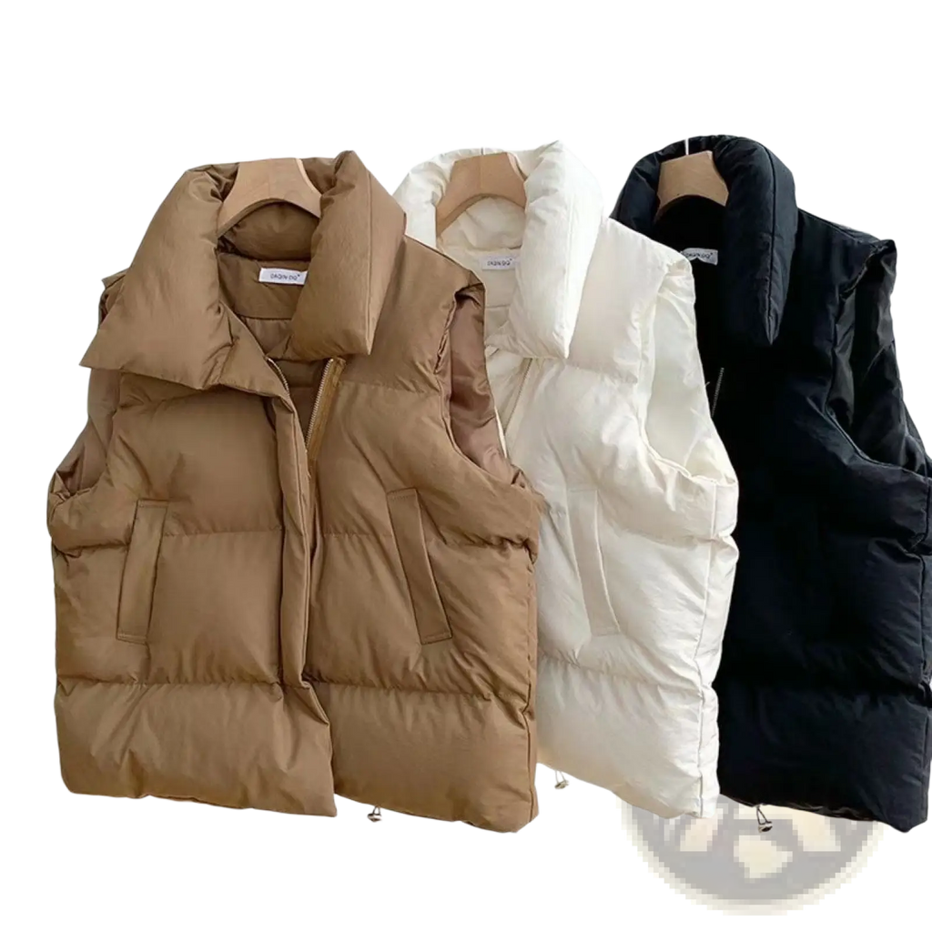 Three women quilted puffer vests in tan white and black hanging on a rack for loose sleeveless outerwear