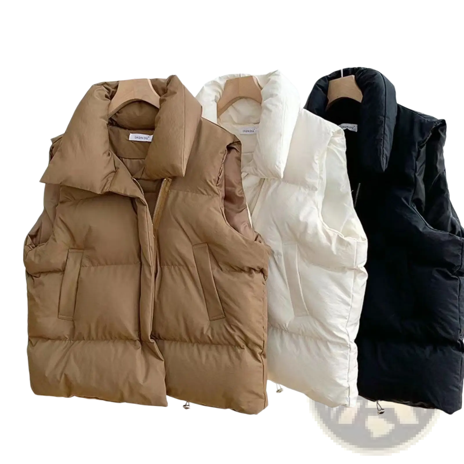 Three women quilted puffer vests in tan white and black hanging on a rack for loose sleeveless outerwear