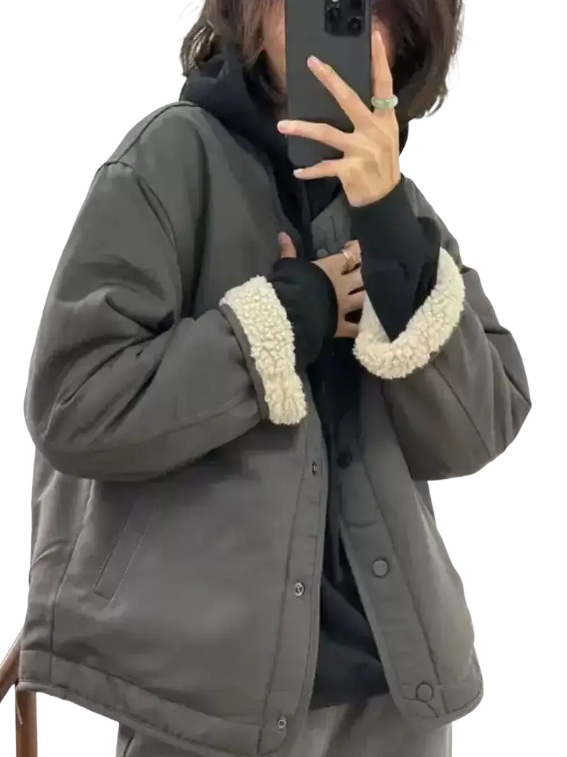 Women shearling bomber jacket in dark gray quilted fabric with cream-colored shearling cuffs visible from the front