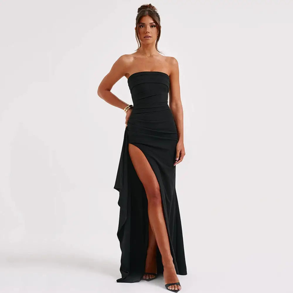 Black strapless pleated maxi gown with ruched bodice and high slit featuring draped fabric detail