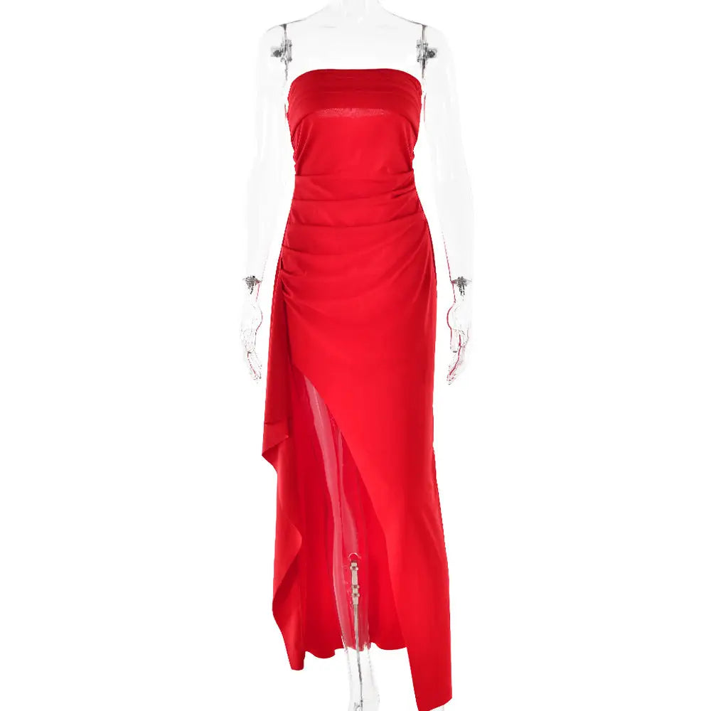 A vibrant red strapless pleated maxi gown with a high slit and ruched bodice displayed on a mannequin