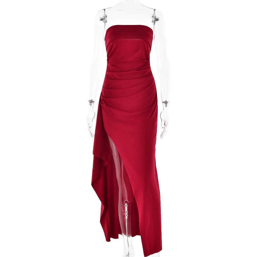 A sleek strapless crimson satin pleated maxi gown with a high slit and ruched bodice for elegant occasions