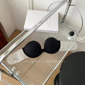 Black strapless adhesive push up bra with clear flexible band designed for support and discreet wear