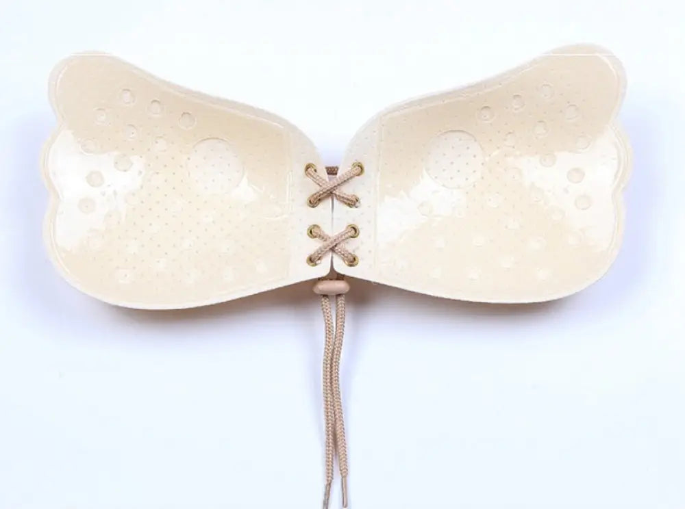 Beige silicone adhesive lace up strapless push up bra with textured wings for enhanced support and comfort