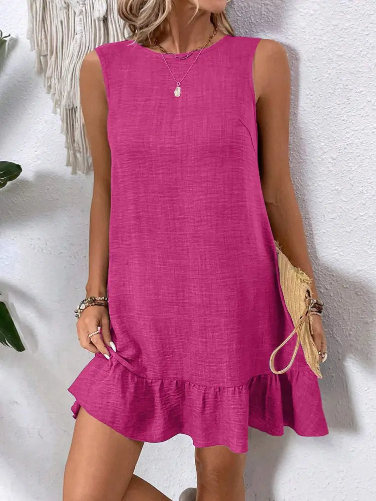 A vibrant fuchsia sleeveless summer vacation beach dress with ruffled hem and subtle textured relaxed fit
