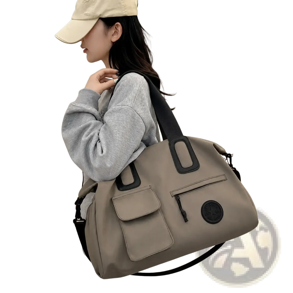 Beige women travel duffel bag with black reinforced handles and circular logo patch large carry on tote
