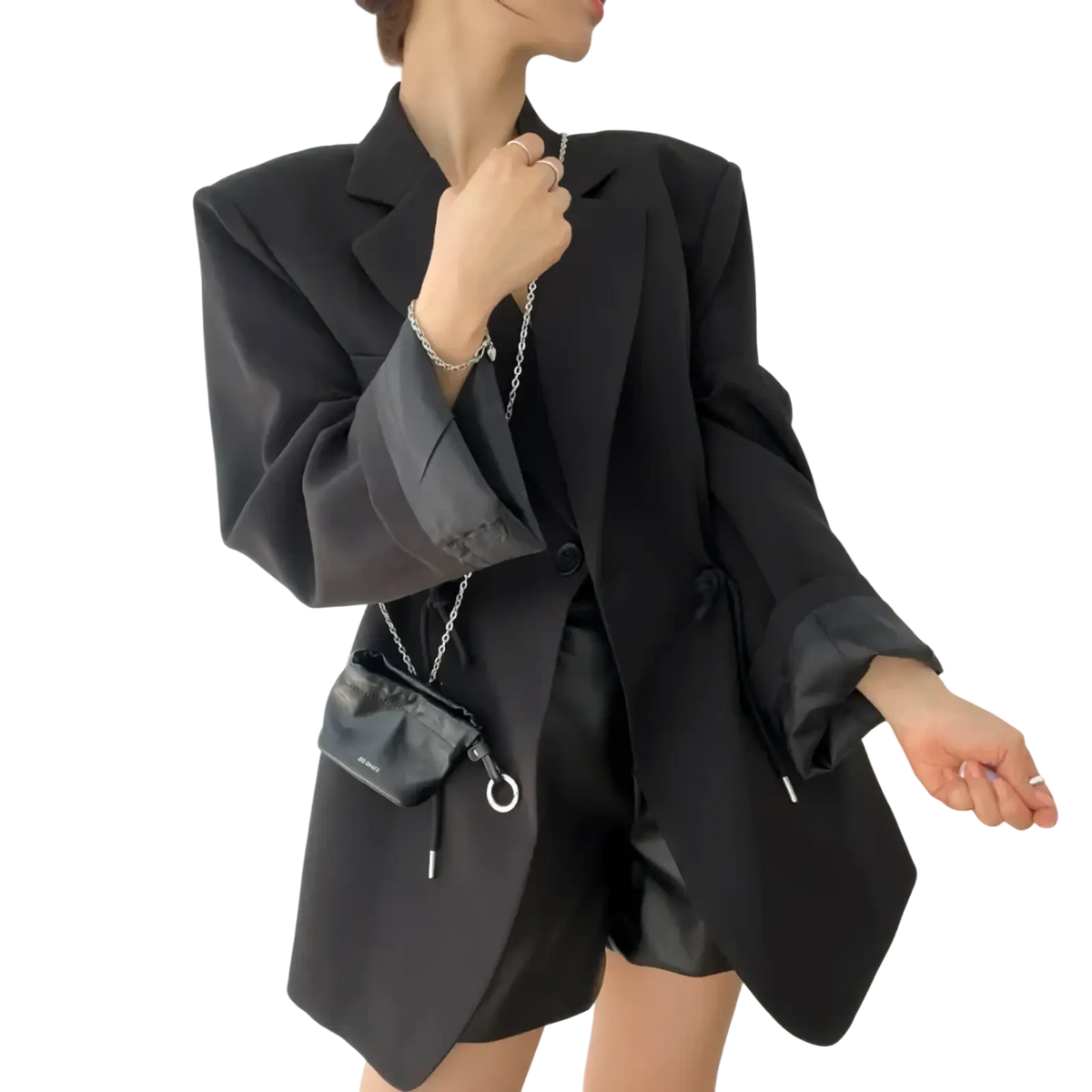 Black leather crossbody bag with silver chain strap and circular metal ring accent complements women vintage drawstring waist blazer