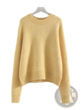 A soft pale yellow women winter knit pullover sweater with cozy textured fabric and ribbed cuffs