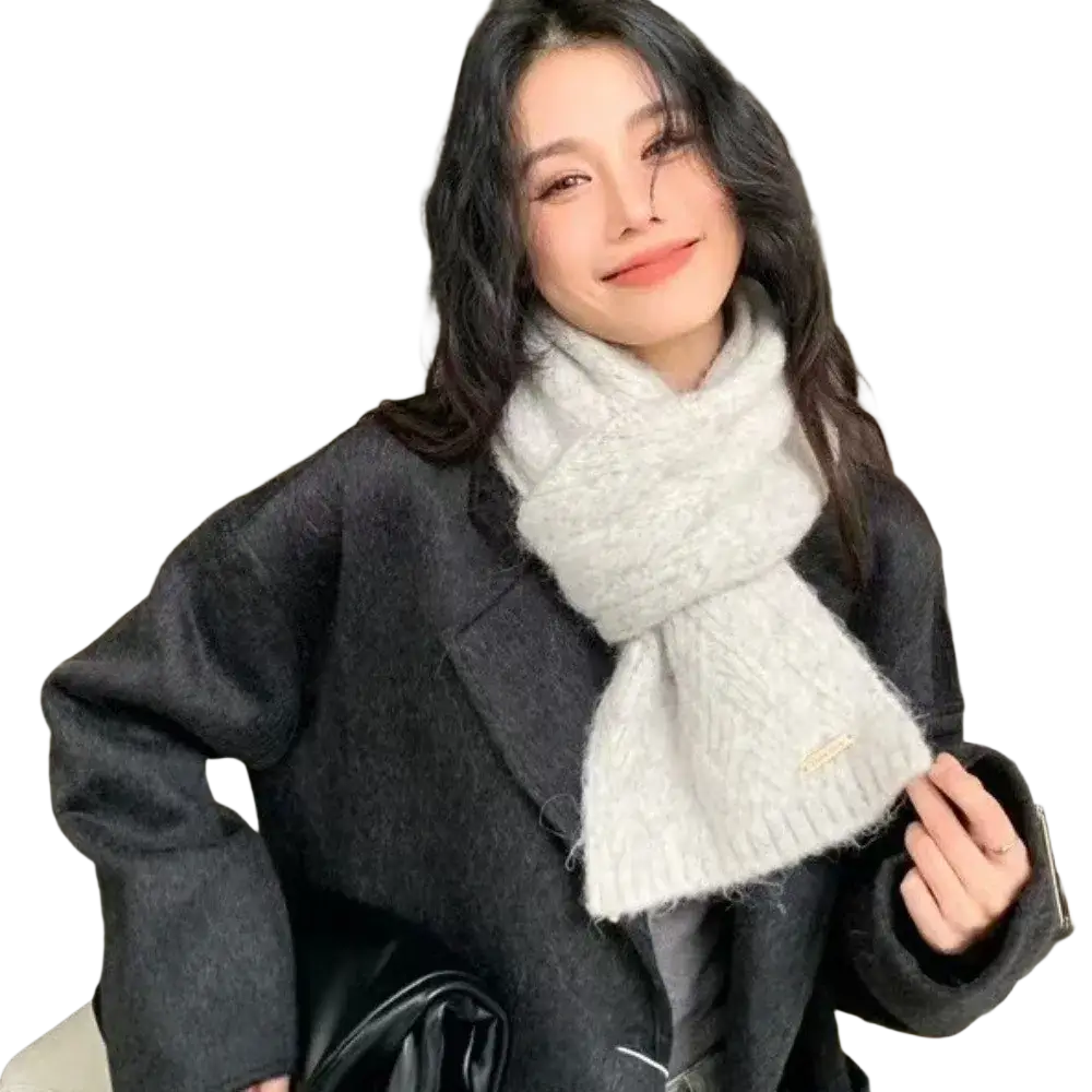 A soft light gray knitted women winter scarf with a textured cable pattern and subtle frayed edges for warmth