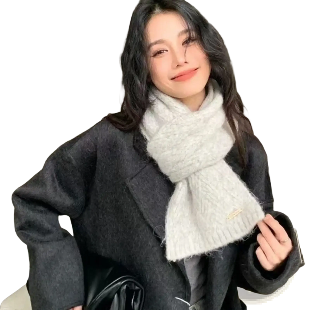 A soft light gray knitted women winter scarf with a textured cable pattern and subtle frayed edges for warmth