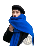 A vibrant royal blue women winter warm solid color pashmina shawl scarf with plush texture wrapped around the neck