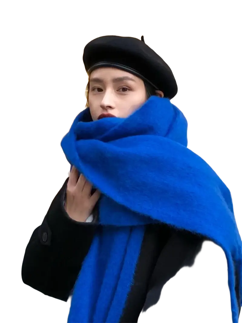 A vibrant royal blue women winter warm solid color pashmina shawl scarf with plush texture wrapped around the neck