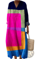 A vibrant women’s abstract v neck patterned maxi dress with long sleeves and bold geometric colors including navy and fuchsia