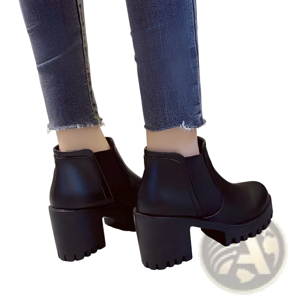 Women’s black leather chunky heel ankle boots with textured block heels shown from the back side