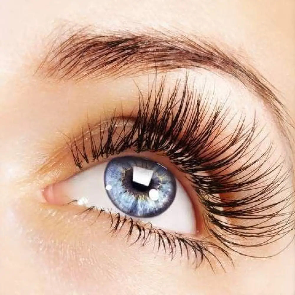 A close-up of a human eye with blue irises and long lashes showcasing Phoera volumizing and lengthening mascara