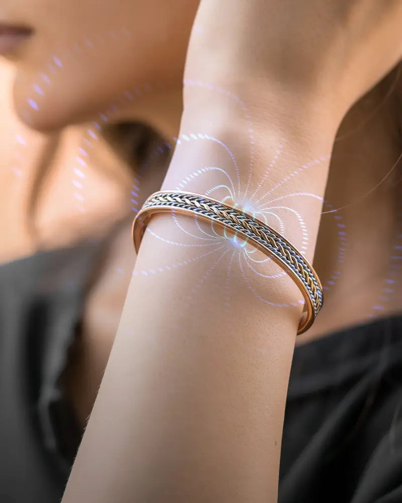 A sleek two-tone copper magnetic therapy bracelet with an intricate braided pattern and polished finish