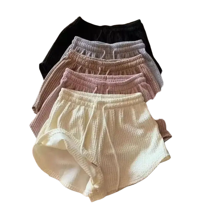 A stack of women’s knit shorts in pastel and neutral tones with ribbed fabric composition and elastic waistbands