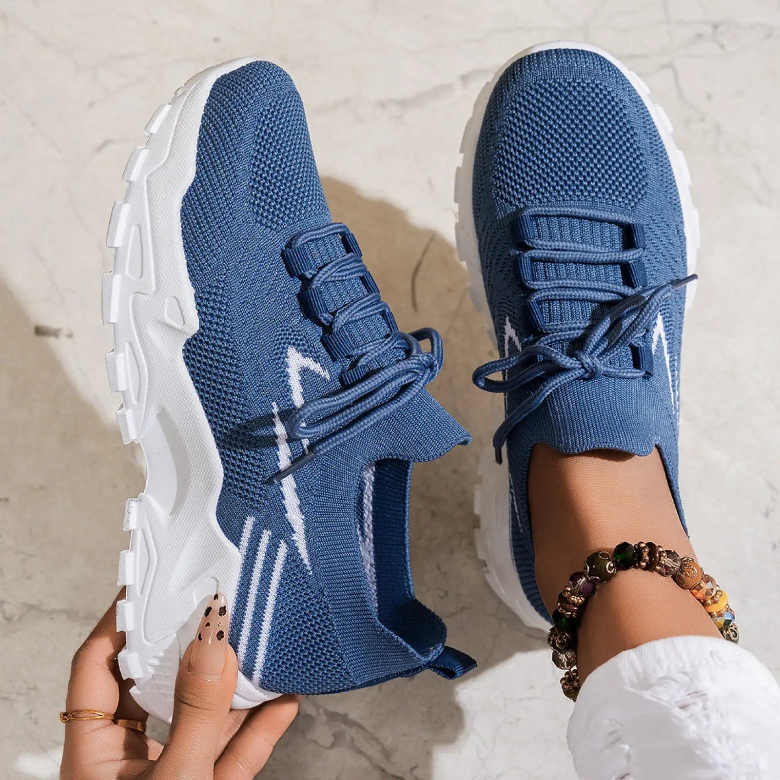 Blue knit women’s lightweight breathable mesh lace up sports sneakers with white soles and laces featuring modern design