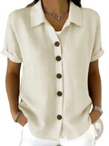 Cream-colored women’s linen blend short sleeve shirt with rolled cuffs and dark brown buttons