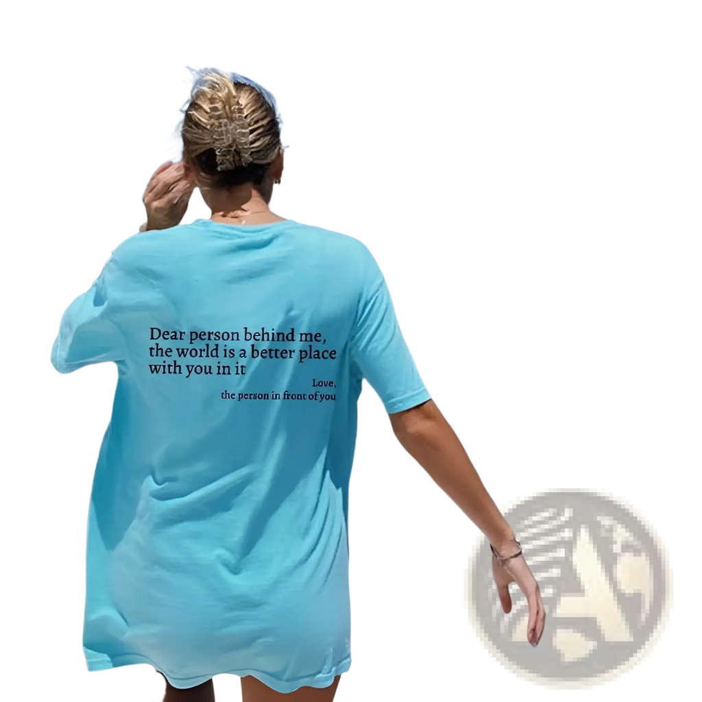Back view of a light blue women’s oversized short-sleeved t-shirt with a printed slogan graphic on the back