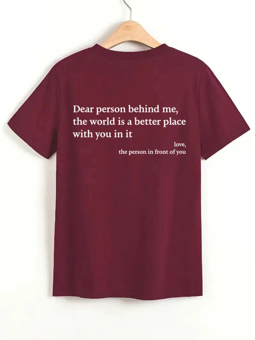Back view of a maroon women’s oversized cotton t-shirt with short sleeves and white slogan print on the back