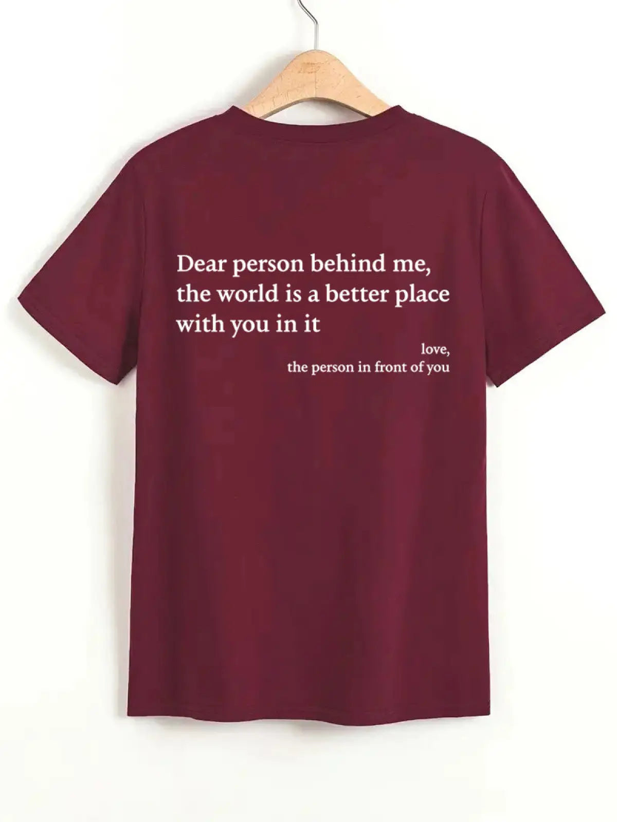 Back view of a maroon women’s oversized cotton t-shirt with short sleeves and white slogan print on the back