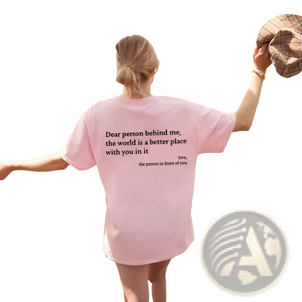 Women’s oversized pink t-shirt made of soft fabric featuring black slogan print on the back side