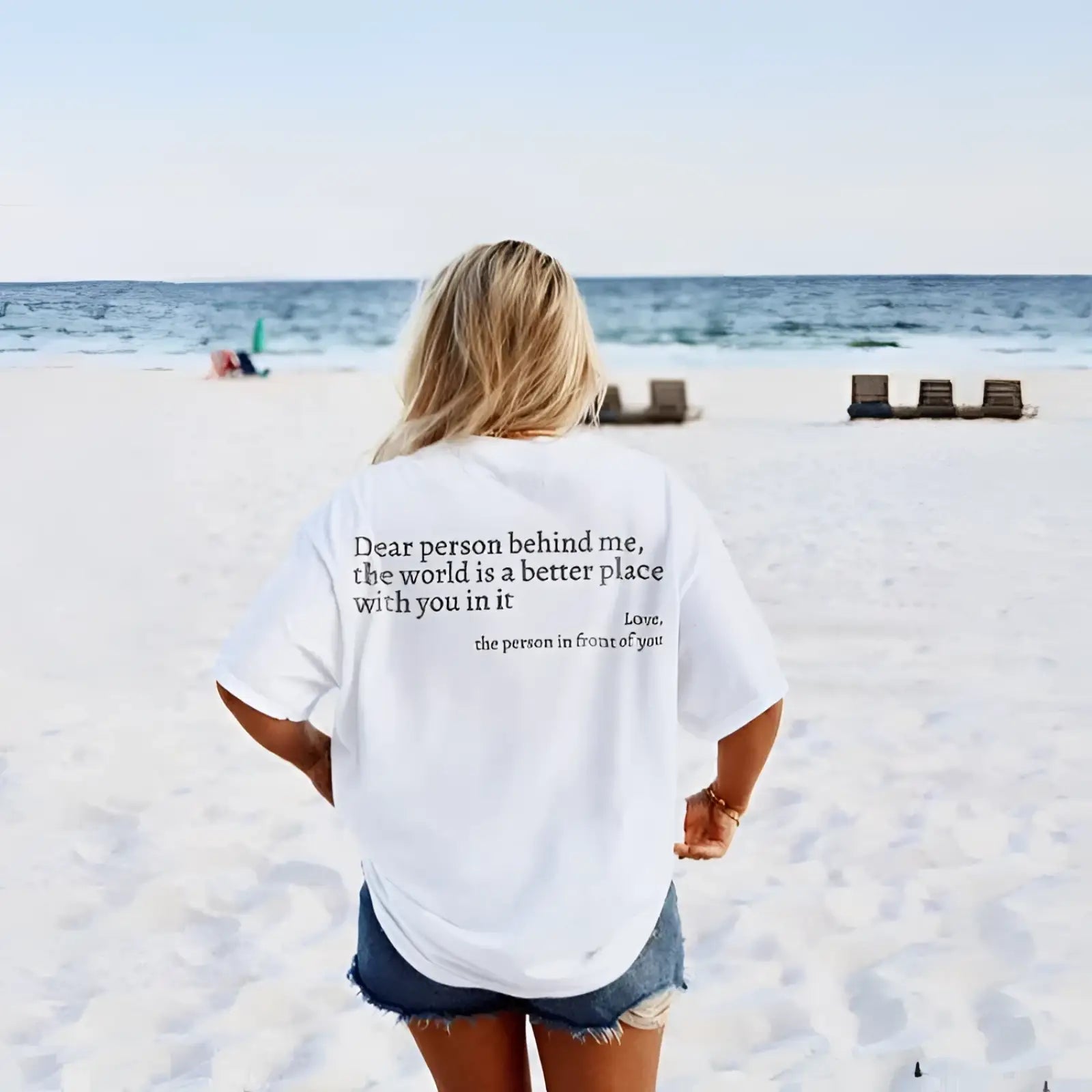 Back view of white oversized cotton t-shirt for women with black slogan print graphic on the back