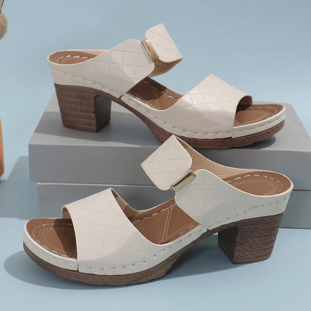 Women’s cream-colored quilted leather mule sandals with textured brown block heel and gold-tone buckle