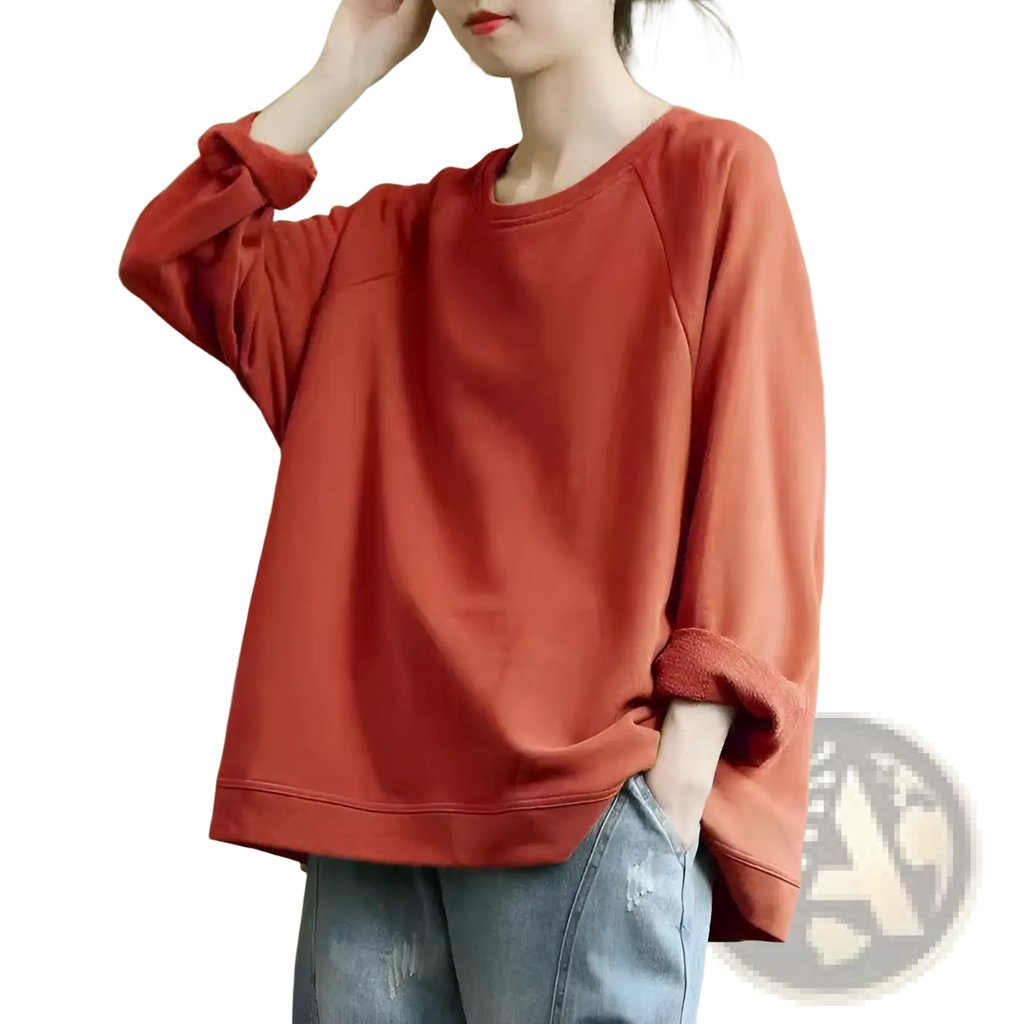 A soft rust-colored women’s relaxed oversized cotton blend pullover sweatshirt with long sleeves and rolled-up cuffs