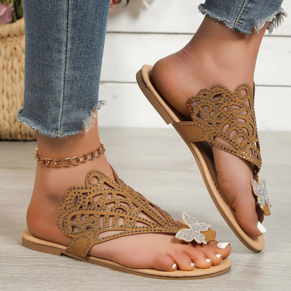 Tan women’s rhinestone hollow flat slip on sandals with butterfly cutout patterns and intricate rhinestone embellishments