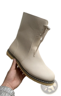 Beige leather women’s shearling lined martin ankle boot with tan rubber sole and visible stitching shown from the back side