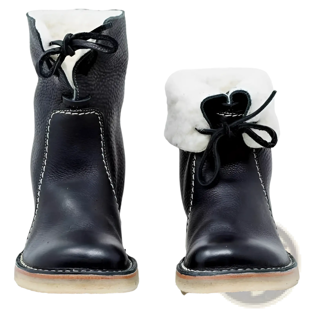 Women’s shearling lined leather martin boots in black with white shearling lining and black laces tied in bows